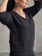 Black layered V-neck top with short sleeves and stacked front hem detail