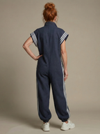 Women’s dark blue zip-front stripe panel jumpsuit, back view with cuffed jogger legs