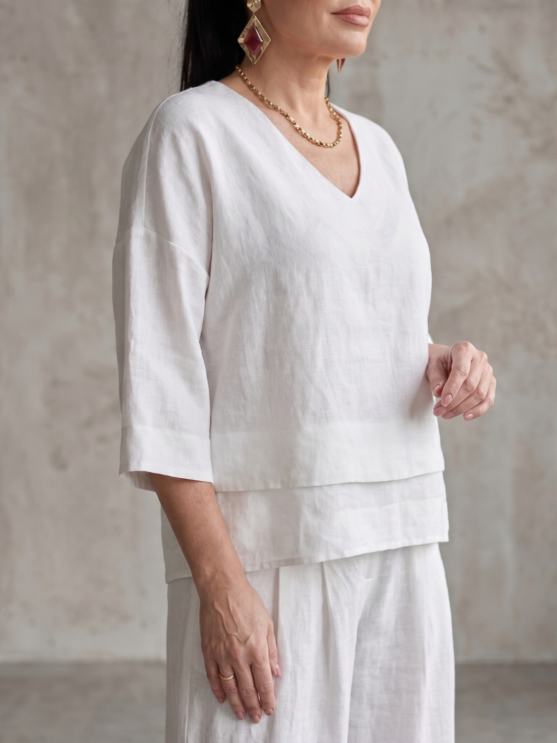 White layered V-neck top with quarter sleeves and double-tier hem detail