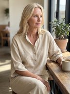 Women's beige button-front tunic and relaxed trousers set, seated close-up