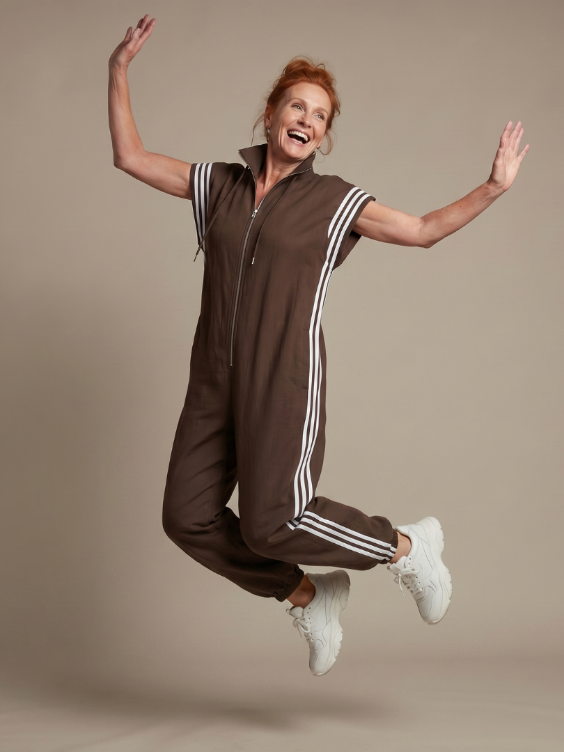Women’s zip-front stripe panel jumpsuit in brown with short sleeves and drawstrings