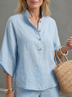 Sky blue button-front tunic top detail with short sleeves and wooden-look buttons
