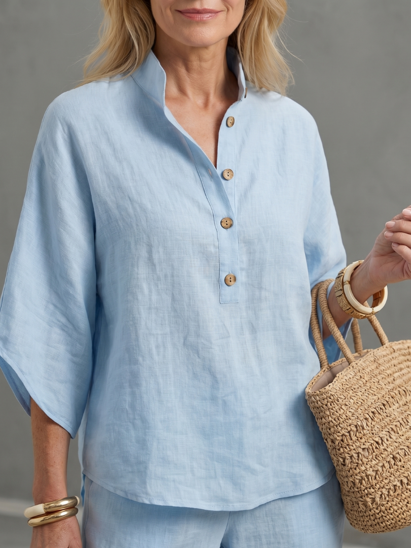 Sky blue button-front tunic top detail with short sleeves and wooden-look buttons