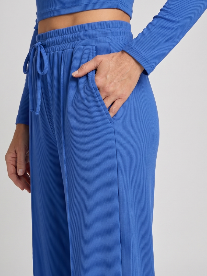 Blue ribbed pants with elastic waistband and tie drawstring (close-up).